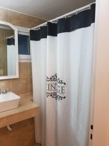 a bathroom with a white shower curtain and a sink at PASAJE EN EL CENTRO DE LOMAS in Lomas de Zamora +6 photos