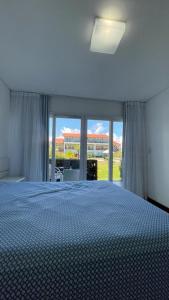 1 dormitorio con cama y ventana grande en Flat Condomínio Beira-Mar en Tamandaré