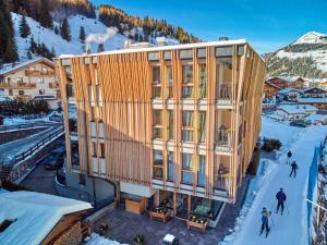 um edifício no topo de uma montanha coberta de neve em Mountain Design Hotel EdenSelva em Selva di Val Gardena