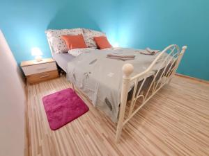 Karlova VesにあるVeľký apartmán 2のベッドルーム(紫色の敷物を使用した白いベッド付)