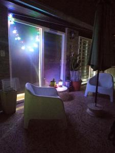 sala de estar con 2 sillas y ventana por la noche en Departamento NALU-RUMU en Mar del Plata
