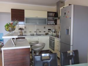 una cocina con nevera y algunas sillas. en Apartments Dilja, en Malinska