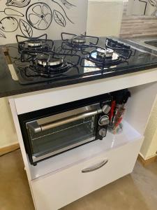 a kitchen counter with a stove top oven at Casa Estúdio com cozinha completa - Centro Serra do Cipó in Serra do Cipo