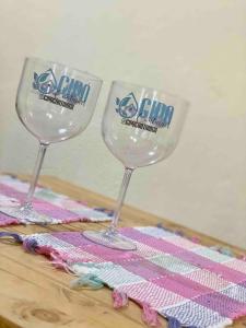two wine glasses sitting on top of a table at Casa Estúdio com cozinha completa - Centro Serra do Cipó in Serra do Cipo