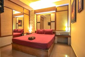 una camera da letto con un grande letto rosso con specchi di Bar Oz Riverside Guesthouse a Phnom Penh