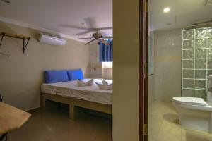 una camera con letto e un bagno con servizi igienici di Bar Oz Riverside Guesthouse a Phnom Penh