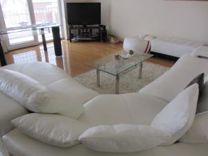 un soggiorno con divano bianco e tavolo in vetro di Apartments Dilja a Malinska