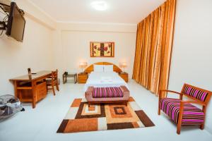 1 dormitorio con cama, mesa y escritorio en Grima Hotel en Huánuco