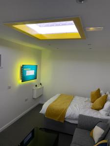 a bedroom with a bed and a tv on the wall at Balco Sherwood Studio in Nottingham