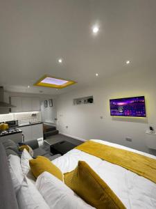 a bedroom with a large bed and a kitchen at Balco Sherwood Studio in Nottingham