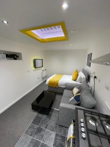 a bedroom with a bed and a kitchen with a stove at Balco Sherwood Studio in Nottingham