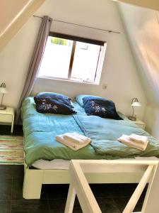 a bedroom with a bed with blue sheets and a window at Beachhouse SeaBreeze in Noordwijk
