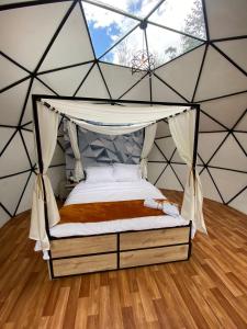 RESERVA CATEDRAL Glamping في زيباكويرا: غرفة نوم مع سرير مظلة في خيمة