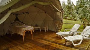 a tent with a table and chairs in it at RESERVA CATEDRAL Glamping in Zipaquirá
