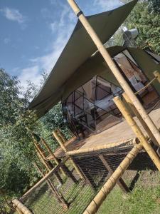 een grote groene tent bovenop een houten terras bij RESERVA CATEDRAL Glamping in Zipaquirá