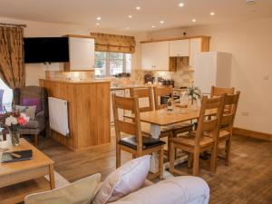 a kitchen and living room with a table and chairs at The Turnip House in Acton Scott