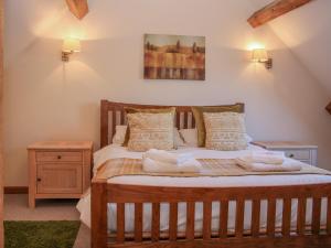 a bedroom with a wooden bed with towels on it at The Turnip House in Acton Scott