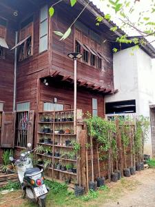 a scooter parked in front of a wooden building at Kwan Phayao LakeHouse กว๊านพะเยาเลคเฮ้าส์ in Phayao +43 photos