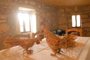 dos pollos sentados sobre una mesa en Casa do Tear, en Macieira de Alcoba