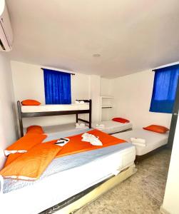 a bedroom with two beds and blue curtains at Hotel Y Restaurante La Quinta in Cartagena de Indias