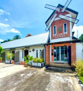 un edificio con un mulino a vento sopra di esso di Belukar Lodges Private Homestay a Pantai Cenang