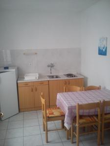 cocina con mesa, fregadero, mesa y sillas en Apartments Filip, en Omiš