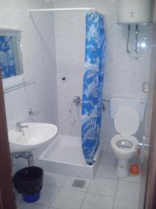 y baño con lavabo, aseo y cortina de ducha. en Apartments Filip, en Omiš