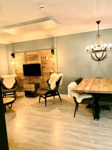 a living room with a table and chairs and a television at Kappeberg Lodge in Winterberg