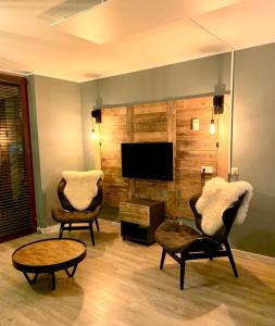 uma sala de estar com 2 cadeiras e uma televisão de ecrã plano em Kappeberg Lodge em Winterberg