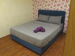 a bed with a blue headboard and a purple pillow on it at Oscar Inn in Petaling Jaya