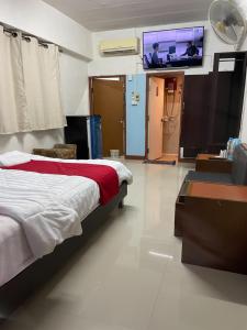 a bedroom with a bed and a flat screen tv at Gedkanok Apartment in Bangkok