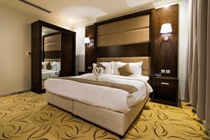 ein Hotelzimmer mit einem großen Bett und einem großen Spiegel in der Unterkunft Ebreez Hotel in Dschidda