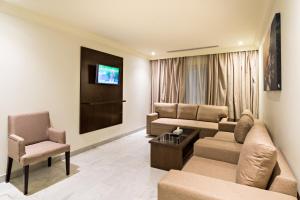ein Wohnzimmer mit einem Sofa und einem Stuhl in der Unterkunft Ebreez Hotel in Dschidda