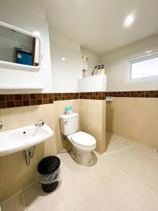 a bathroom with a toilet and a sink at Rueangrat Hotel in Ranong