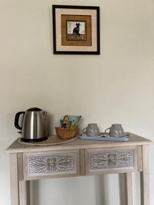 a table with a tea kettle and a basket on it at LA MAISON DE TRIBOULET Chambres et table d'hôtes -Amboise- in Pocé-sur-Cisse