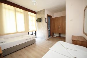 a large room with two beds and a window at Delta Hotel in Didim