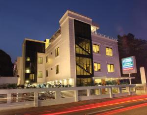 a large white building with a sign in front of it at Hotel Park Residency in Kozhancheri