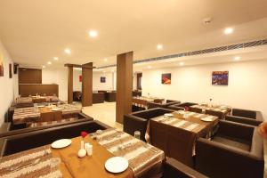 a dining room with tables and chairs in a restaurant at Hotel Park Residency Kozhencherry in Kozhancheri