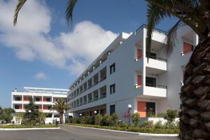 een wit gebouw met een palmboom ervoor bij Margarona Royal Hotel in Preveza