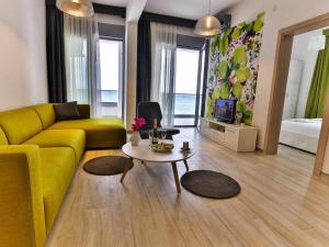 a living room with a yellow couch and a table at Apart Hotel Sea Fort in Sutomore