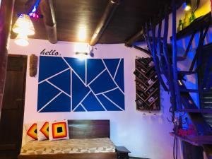 a room with a bed and a blue wall at Earth House Sri Lanka in Dodangoda