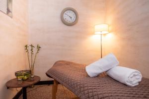 a room with a bed with a clock on the wall at Amsterdam Hotel in Belgrade