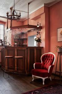 a living room with a red chair and a bar at Hotel Helgeand Wisby in Visby