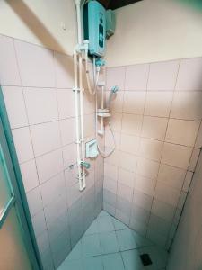 a shower in a bathroom with pink tiles at Spring Plaza Hotel in Dasmariñas