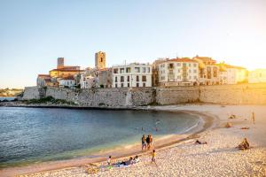 un groupe de personnes sur une plage près de l'eau dans l'établissement Penthouse Antibes apartment, à Antibes