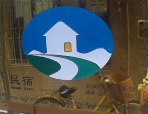 a sign in a window with a house on it at 醒覺旅人-訂房後需聯繫轉帳 in Tainan