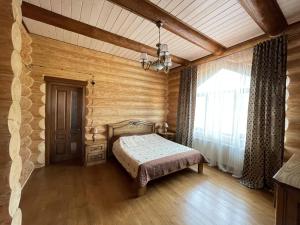 タターリウにあるГостевой дом "Уютный"の木製の壁のベッドルーム1室(ベッド1台付)