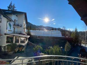 una vista de una casa con el sol en el cielo en Pensiunea Crocus - Sauna & Billiard en Poiana Brasov