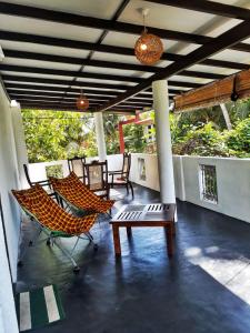 eine Terrasse mit Stühlen und einem Tisch auf der Veranda in der Unterkunft Weligama Bay House in Weligama