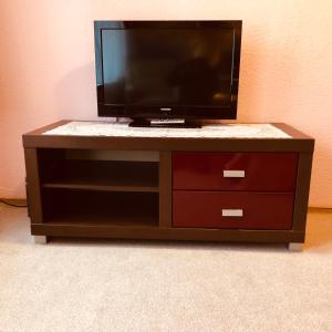 a tv sitting on top of a wooden entertainment center at Just Pension & Bar in Gadebusch